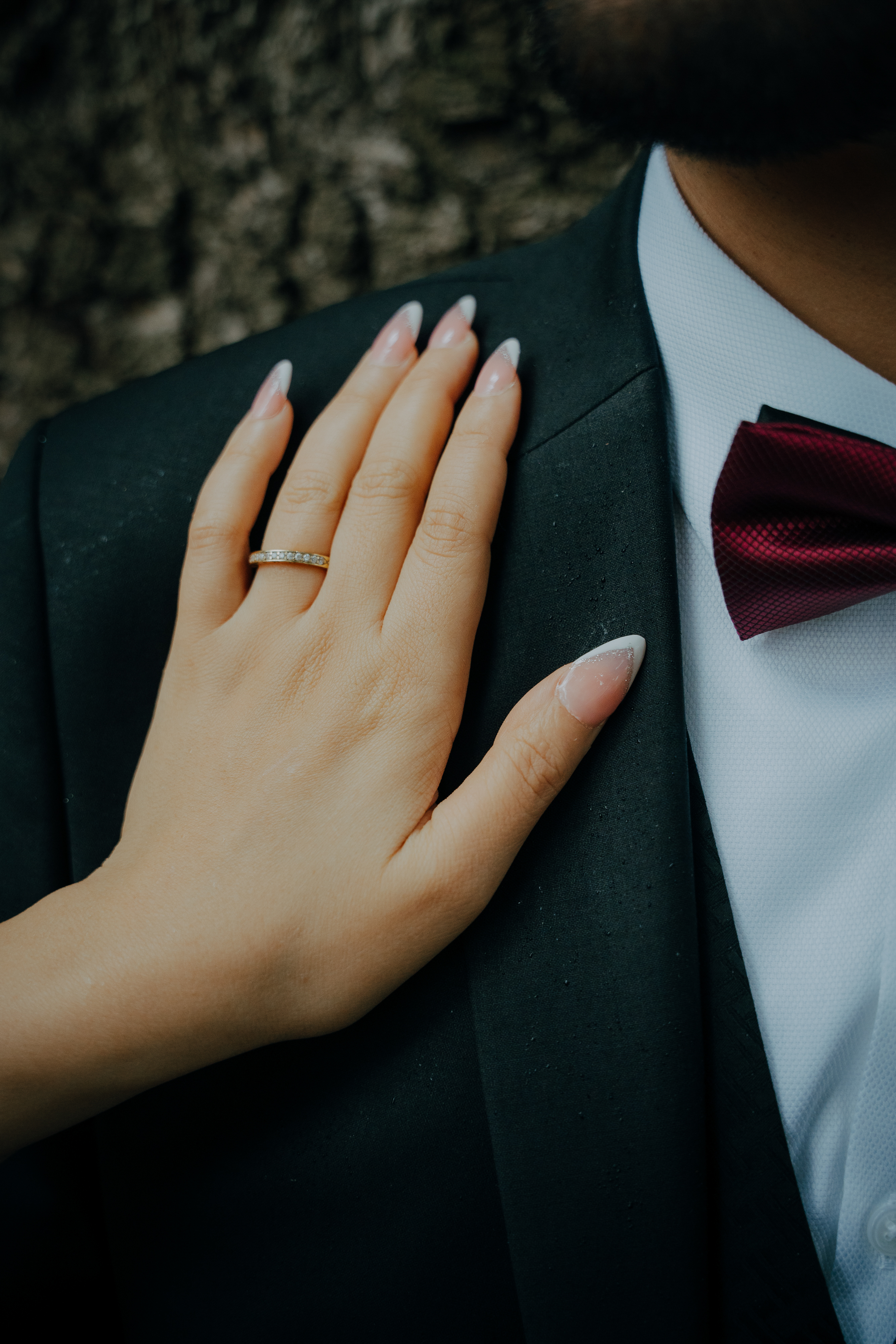 Main de la mariée posée sur l'épaule du marié